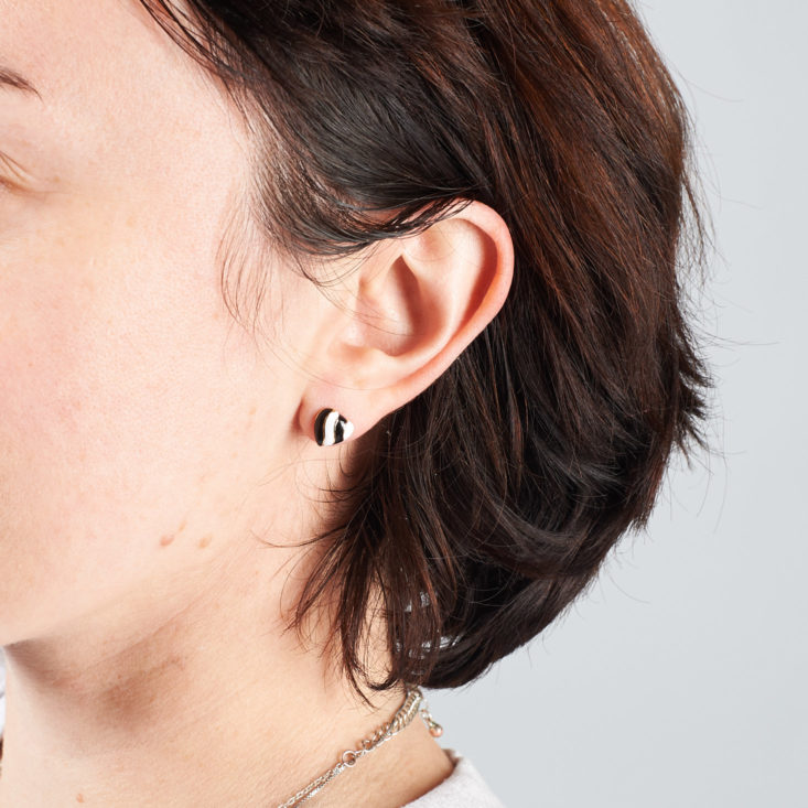 black and white heart earrings on a person