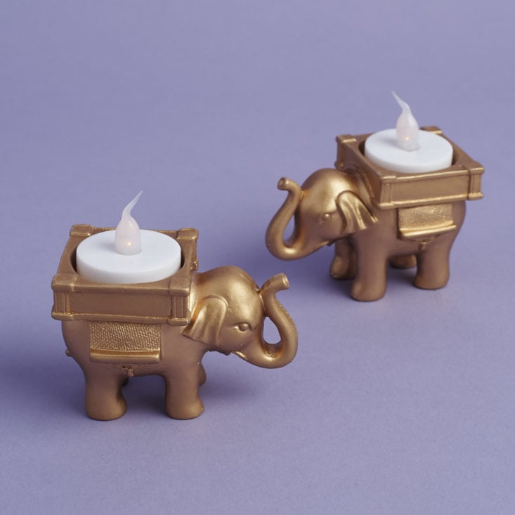 a pair of elephant votive candle holders with battery operated tea lights in them