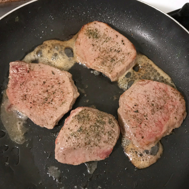 beef medallions cooking in pan