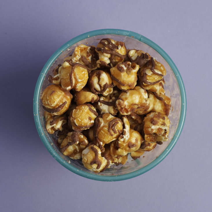 a look inside of a tub of chocolate drizzled caramel corn