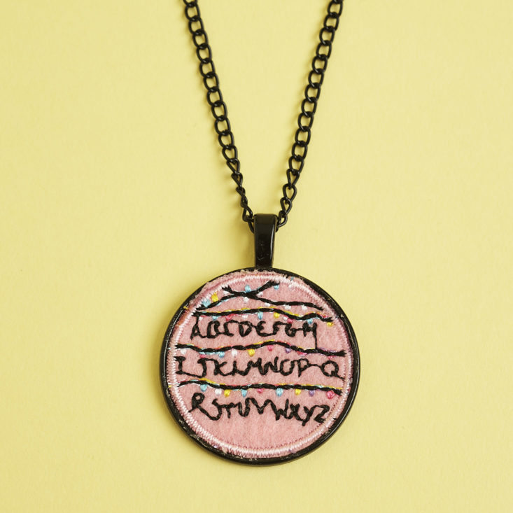 close up of Stranger Things stitched pendant necklace