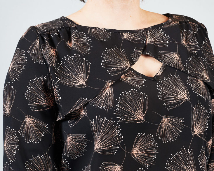 There's a keyhole detail in the front of this printed black blouse