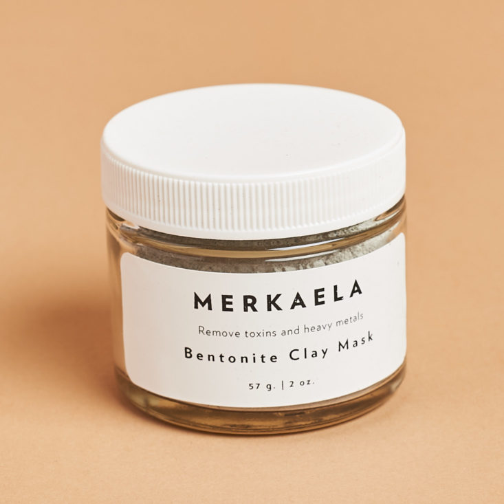 bentonite clay mask in a short glass jar with white lid and label