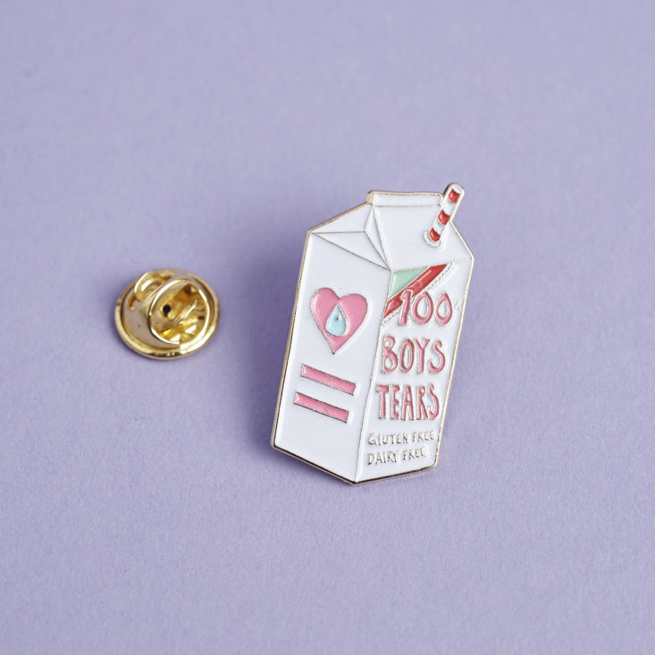 a milk-carton-shaped enamel pin that's white and says "100% boys tears" on it