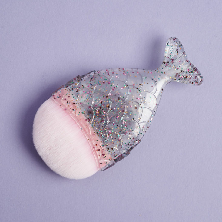 a pink foundation brush with a sparkly handle that looks like a fish tail