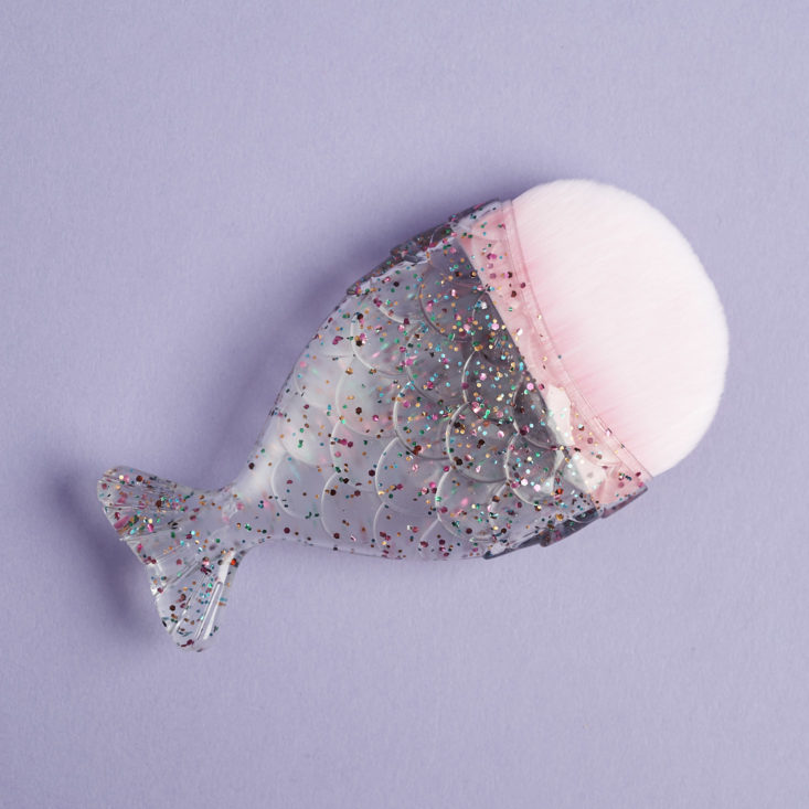 a pink foundation brush with a sparkly handle that looks like a mermaid's tail