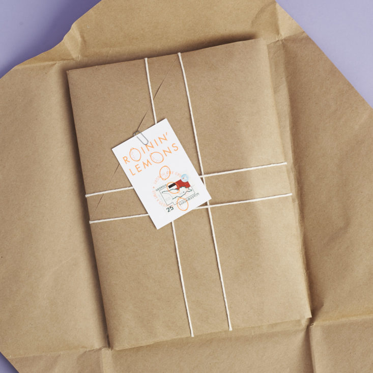 beautifully wrapped item s in kraft paper and twine with passport stamp