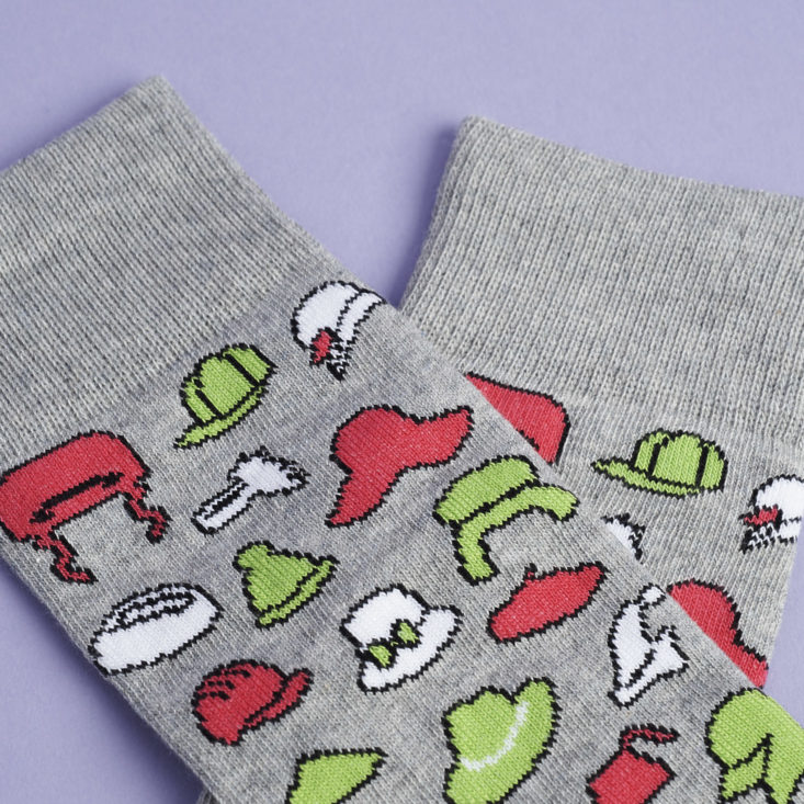 close up of grey socks with different red green and white hats