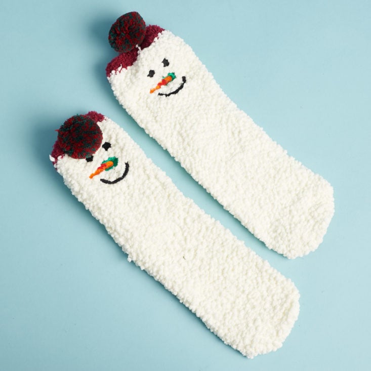 white nubbly socks with snowman faces and pompoms on the ankles