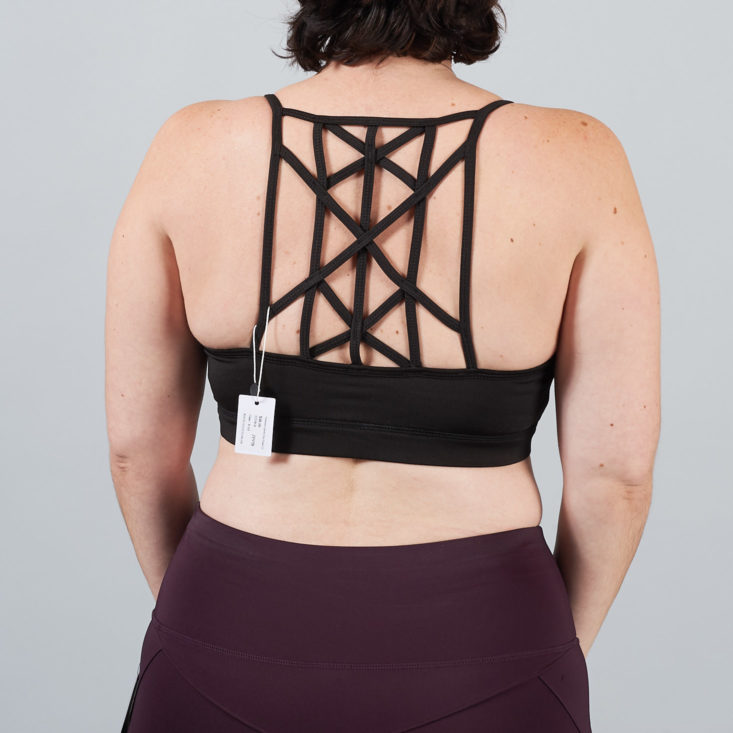 strappy details on the back of a sports bra worn by a woman