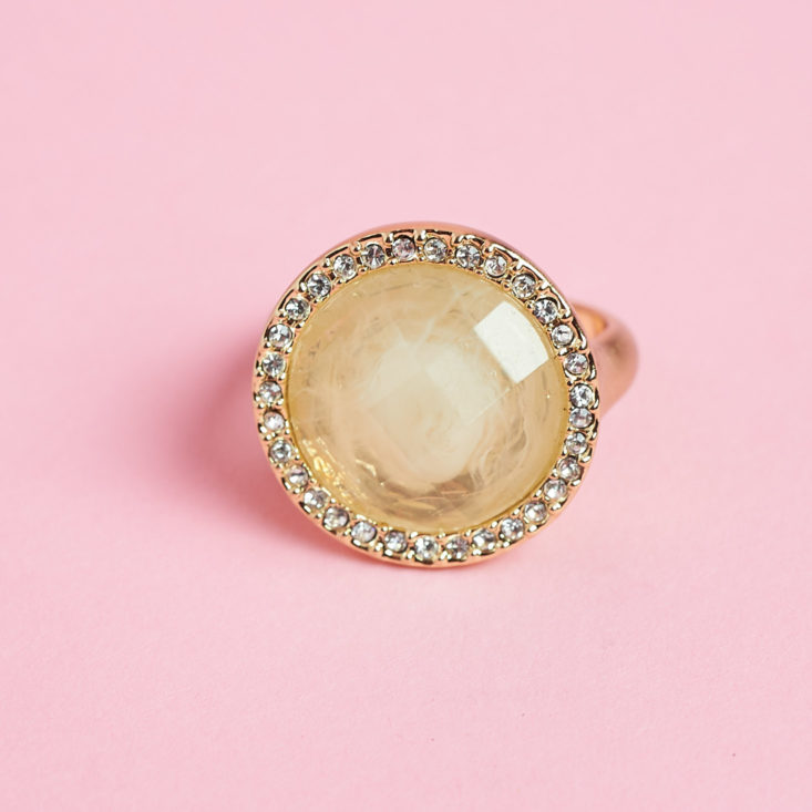 crystals around a circle shaped yellowish gem on a ring