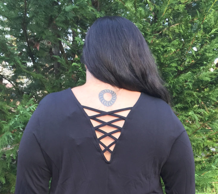 back of black dress showing v-neck with criss cross detail
