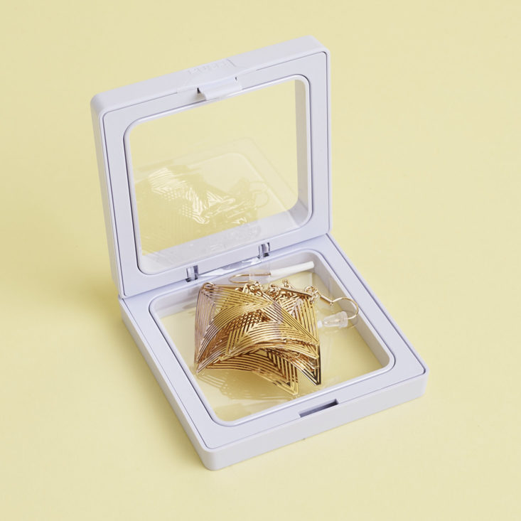 Gold dangly triangle earrings in open case