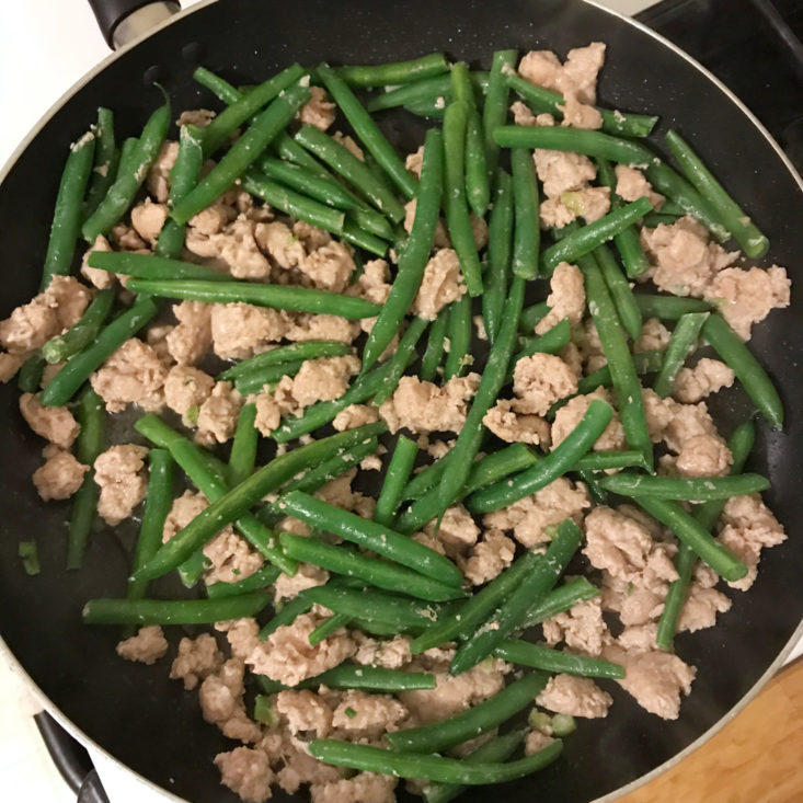 ground pork and green beans cooking in pan