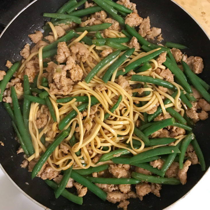 lo mein noodles, ground pork, and green beans cooking in frying pan