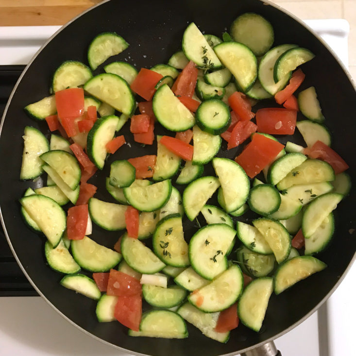 zucchini and tomatoes cooking in frying pan