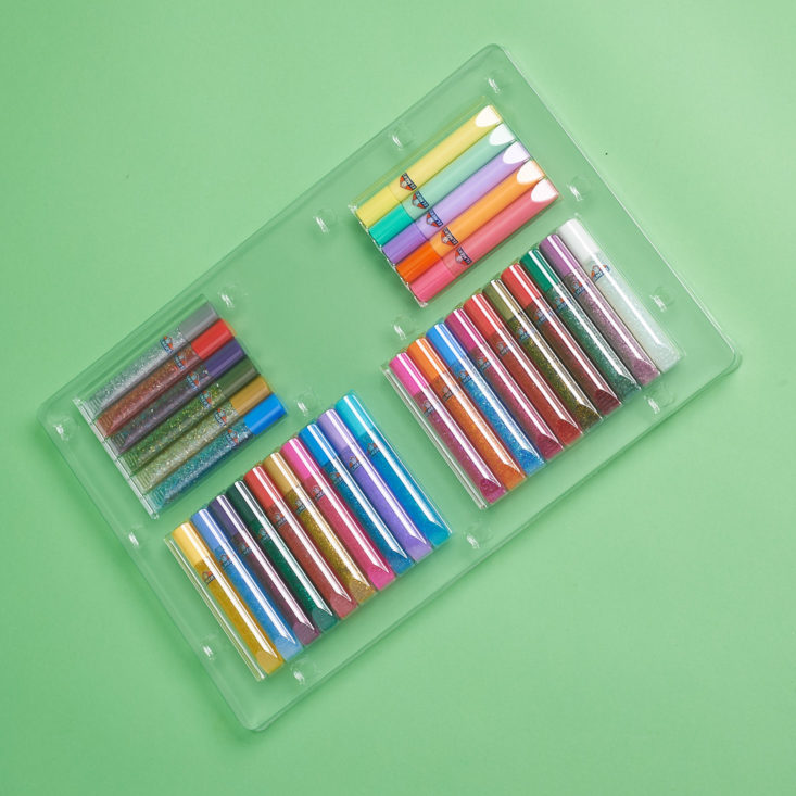 A rainbow of various types of glittery glues are included