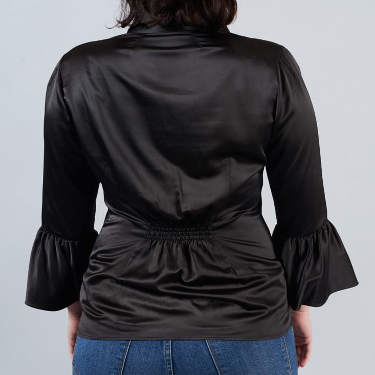 bell sleeved black blouse from behind