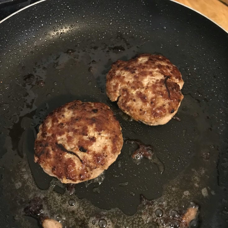 pork burger patties cooking in pan