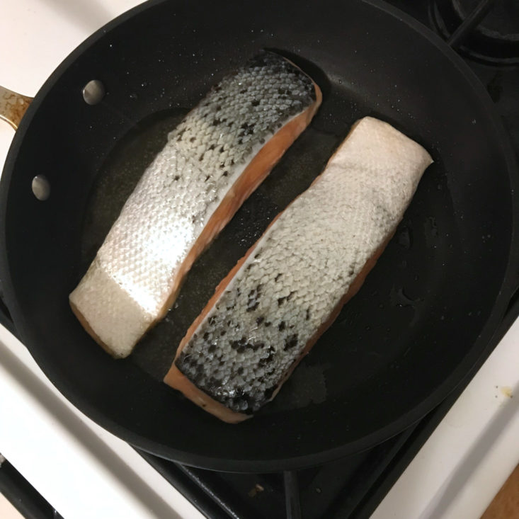 salmon searing in pan, skin side up