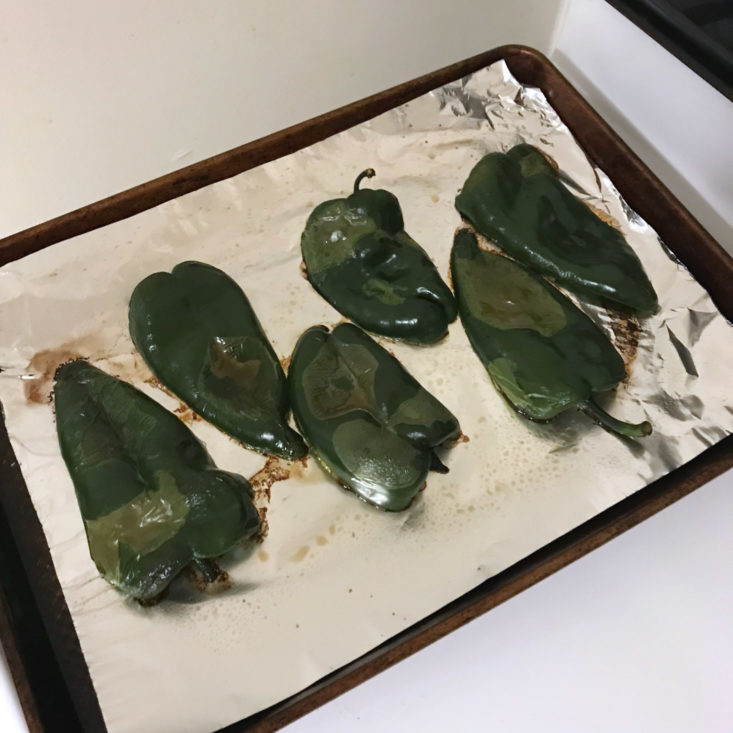 halved poblano peppers on baking sheet