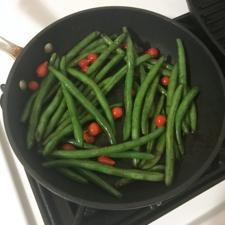 pickled Peruvian peppers added to green beans in skillet