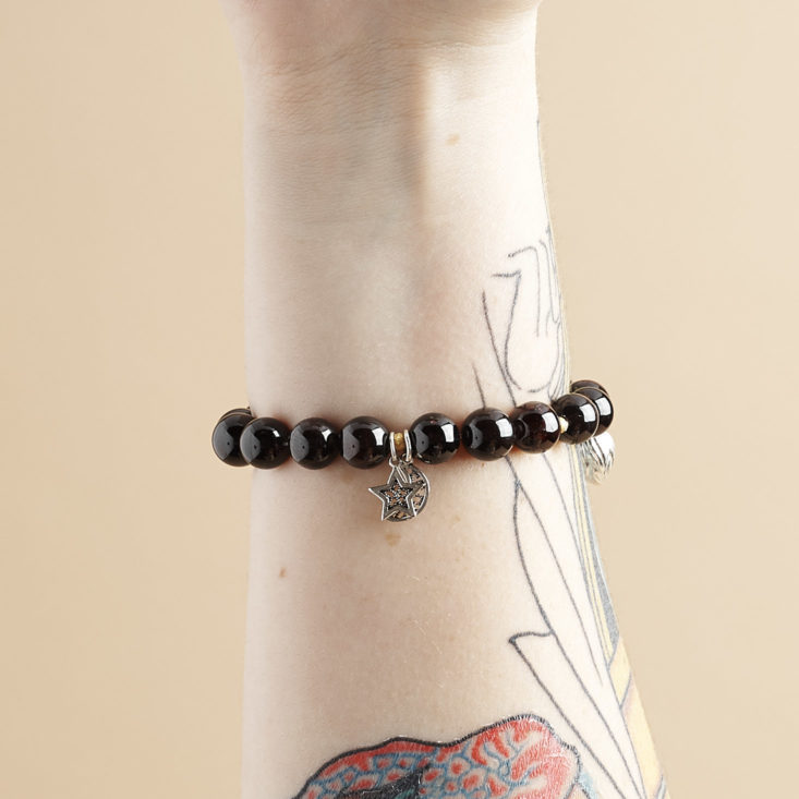 Wristicuffs garnet and silver charm bracelet on arm