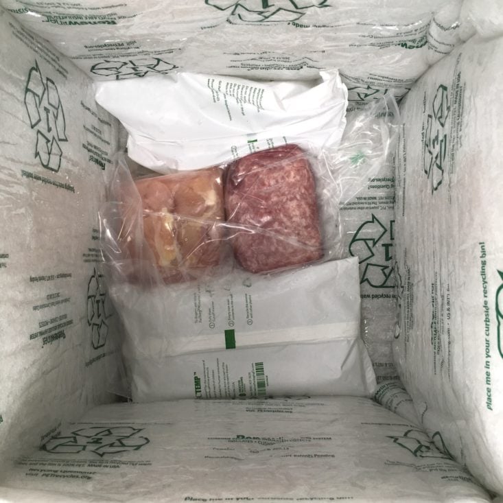 a top-down view of the diced chicken and ground pork nestled amid a bunch of ice packs at the bottom of the box